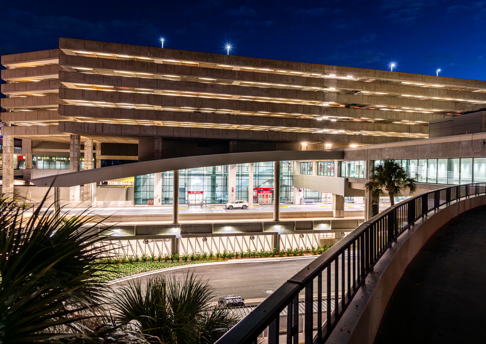 Nighttime exterior view of Tampa International Airport’s Express Curbsides, showing illuminated curbside levels and terminal structure designed to improve passenger flow.