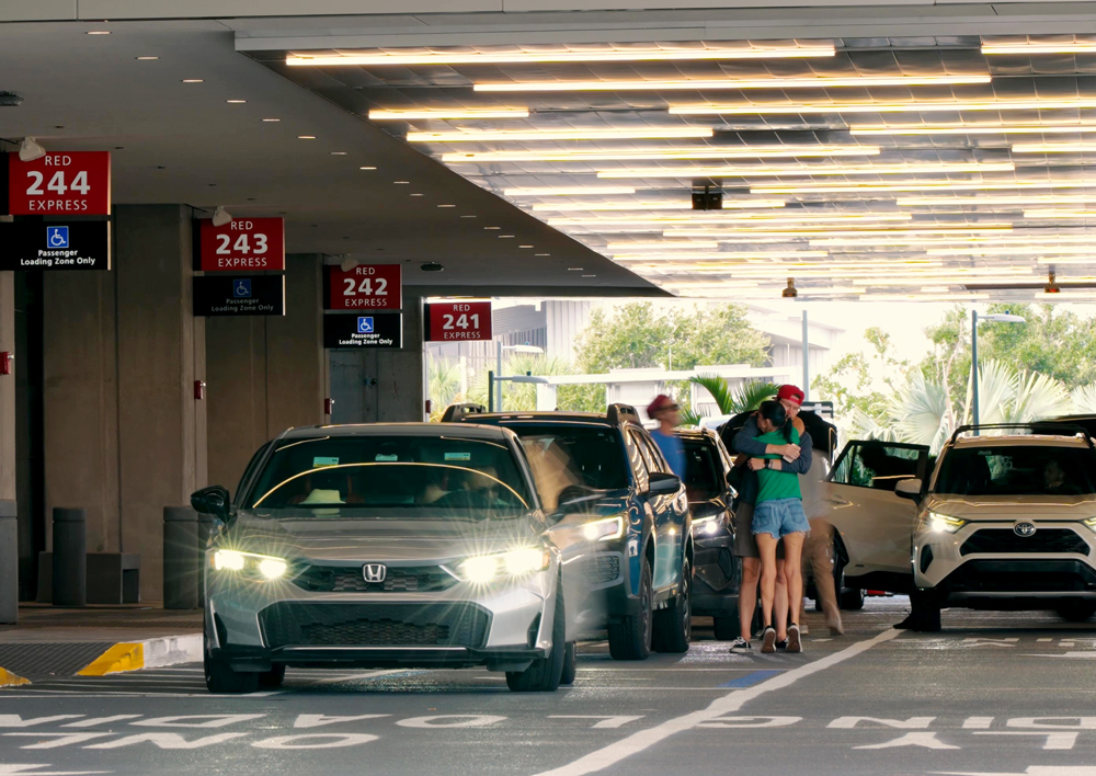 Vehicles queue at the Red Express Curbsides at Tampa International Airport as travelers load and unload under a covered canopy with clearly marked express loading zones.